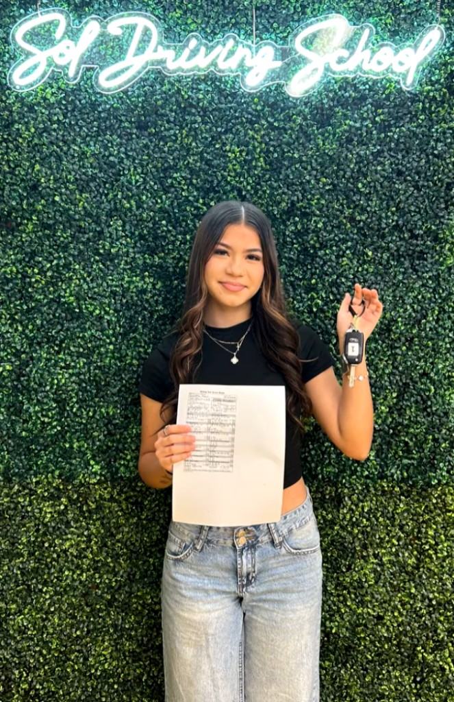 Student celebrating with car keys at SOL Driving School